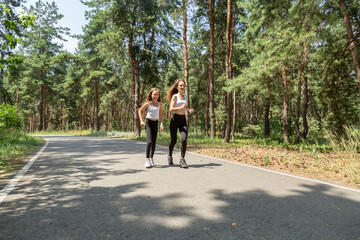 Obraz premium Mother and daughter walking in the forest on a summer day.