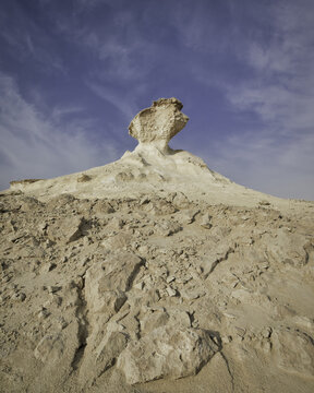 View of a surreal chalk landscape sculpted by wind and time under a vast blue sky, a natural monument in the desert, Zekreet, Al Sheehaniya Municipality, Qatar.