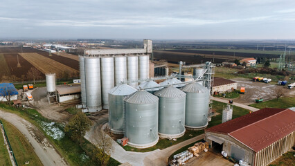 Aerial view of a cluster of silver grain silos standing tall against the muted landscape, a testament to agricultural industry, Sremska Mitrovica, Vojvodina, Serbia.