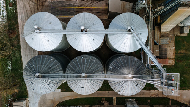 Aerial view of silver silos standing tall against the muted landscape, a testament to industry and agriculture, Sremska Mitrovica, Vojvodina, Serbia.