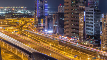Obraz premium Dubai marina with traffic on sheikh zayed road panorama day to night timelapse lights turn on.