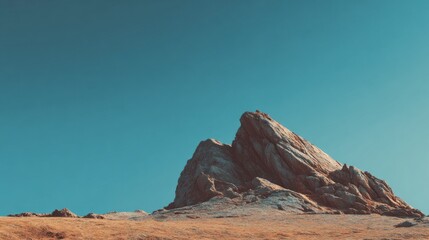 Rocky mountain formation under a clear turquoise sky in a desert environment