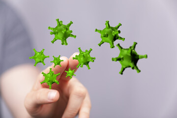 Conceptual image of green virus particles manipulated by a human hand, illustrating control or awareness of il
