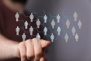 Image depicting the concept of a digital network or community with a person's hand interacting with virtual connections representing people. Sho