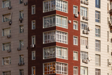 View of contrasting textures and colors as sunlight warms the facade of a modern building, a blend of brick and stone, Aktau, Mangystau Region, Kazakhstan.
