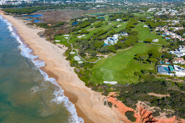 Luxury Living in the Golden Triangle: Cinematic 4K Aerial of Vale do Lobo Royal Golf Course and the Iconic Crimson Cliffs of Praia do Trafal, Algarve, Portugal