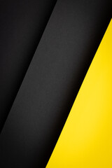 Diagonal stripes of black and yellow paper create an abstract design in a simple setup with no visible objects or text