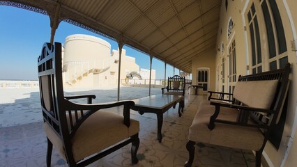 Exterior View of the Historic Mandawa Fort Rooftop Featuring Heritage Architecture and Vibrant Yellow Walls under a Clear Blue Sky
