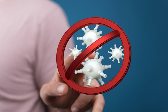 Concept of stopping the spread of viruses and germs with a no entry sign over a model of a virus with a hand p