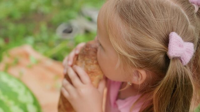 blonde caucasian girl biting bread closeup, crumbs and sand specks on cheek, focused expression, pigtails, textured crust, watermelon at edge, intense mouthful, tactile realism, summer picnic detail