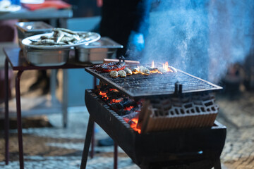 Grilling fresh fish and chorizo on a hot barbecue