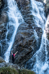 a tourist admiring the power of the waterfall