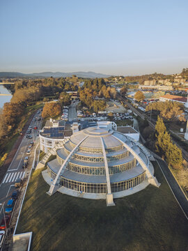 Aerial view of the striking white building with its tiered, semi-circular design casting shadows on the lush green lawn, Vila Nova de Cerveira, Viana do Castelo District, Portugal.