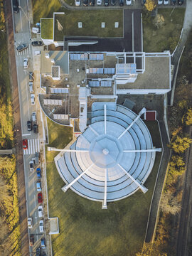 Aerial view of a modern building with a circular design and radiating lines, contrasting with the linear architecture and green spaces, Vila Nova de Cerveira, Viana do Castelo District, Portugal.