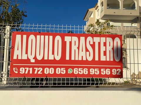 Santa Ponsa, Spain - November 04, 2025: Alquiler de trastero sign displayed prominently on a fence, showcasing rental information and contact details in a sunny outdoor setting