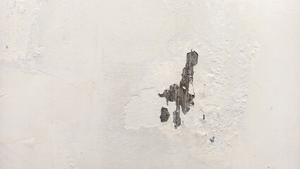 A damaged white wall with a large crack and peeling paint is visible from a frontal viewpoint