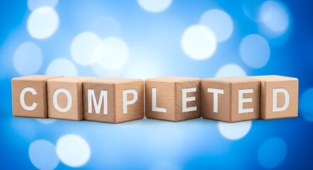 Wooden blocks spelling "Completed" against blue bokeh background