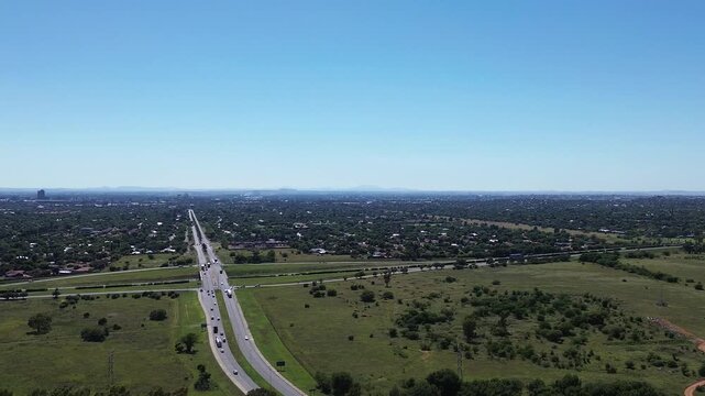 Camera panning right to left over the town of Bloemfontein with the N1 Highway through the town towards the horizon, 4K Aerial Video.