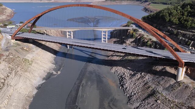 A semi top-down aerial video of the Kuk&euml;s Bridge stretching across the Drin River, with the old bridge and Lake Fierza visible in the background.