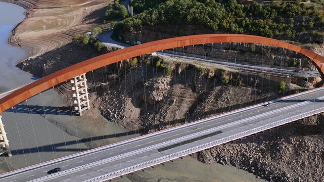 Top-down aerial video of the Kuk&euml;s Bridge stretching across the Drin River with a dry riverbed in Northern Albania. 