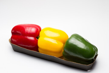 Pimientos tricolor rojo, amarillo y verde sobre fondo blanco