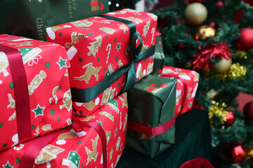 Colored presents gift for Christmas, new year celebration and Christmas tree with colored decorations in the backgrounds.
