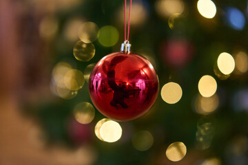 Dangling Red Ornament Against Warm Lights Shallow Depth Emphasizing Sparkle And Texture, Intimate Living Room