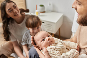 Obraz premium Family gathers around newborn in cozy home setting full of love and warmth