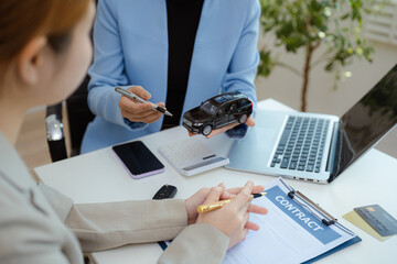 Female signing car insurance document or lease. Writing signature on contract or agreement. Buying or selling new or guarantee.