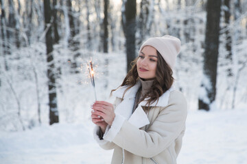 girl with sparkles Bengal fire in winter outdoor. Happy New Year concept. Christmas holiday