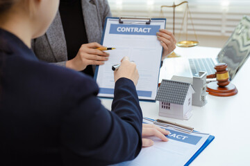 Buying a home or insurance deal, an insurance agent pointing a pen to those interested in renting a house, a contract.