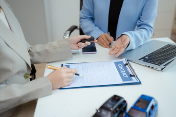Automotive Business, Car Sale or Lease Concept: Car Dealership and sign contracts in car showrooms or car dealership offices.