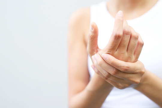 young woman hand pain her wrist. injury, feeling pain from cramp, trigger finger, touching massaging, ache joint. Health care and medical concept.	
