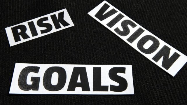 Risk, Vision and Goals typography written on the paper pieces scattered, background.