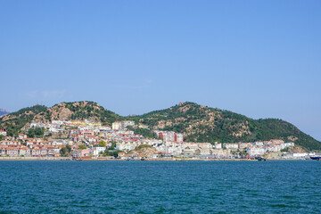 Fototapeta premium Seaside Hills And Town Over Open Water
