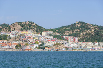 Obraz premium Colorful Coastal Town Across Calm Blue Sea