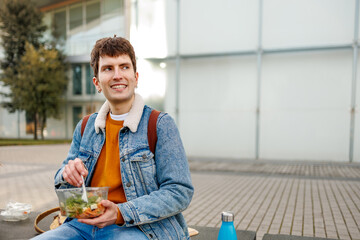 Student eating a healthy salad for lunch outdoors on a college campus