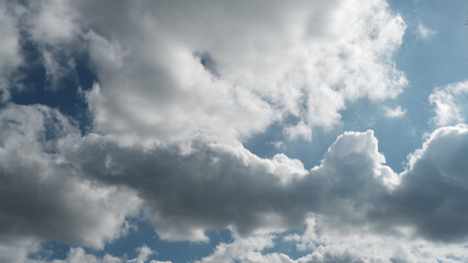 Peaceful blue sky with dramatic white cloud formations on sunny day. Natural background showing bright sunlight and heavenly weather, feeling calm and serene