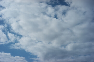 Obraz premium Serene and peaceful blue sky filled with fluffy white cloud. beautiful nature background of daytime weather, offering sense of calm and vastness, perfect backdrop