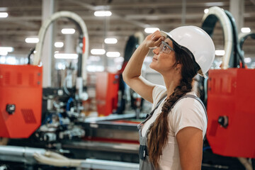 In protective glasses. Woman is in the window making factory