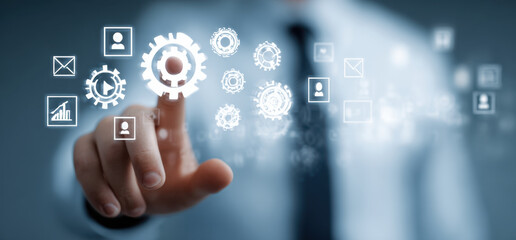 Businessman touching virtual screen with icons of gears and various digital elements, symbolizing technology and innovation in business. scene conveys sense of modernity and progress