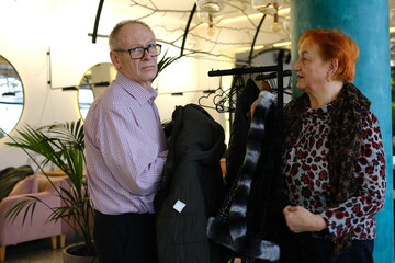 man woman putting on a jacket pulls in a zipper while putting on her warm jacket. High quality photo. High quality photo