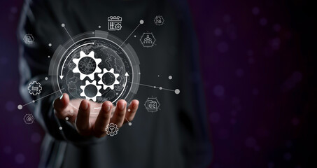 Business hand holding digital gear system with global network icons, representing innovation, workflow automation, company process optimization, and modern business technology.