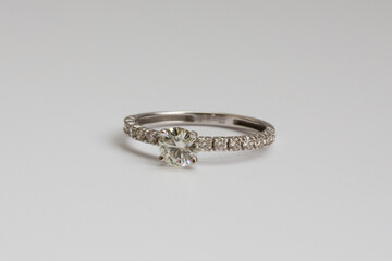 A white gold engagement ring featuring a round-cut diamond, with a pave diamond band for added brilliance.
