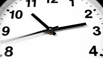 Close-up of a white analog clock face showing the time.