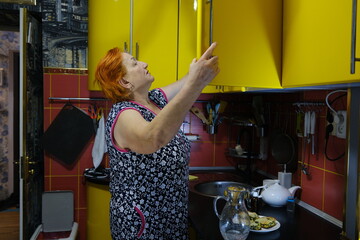 Senior woman cooking food on the stove in kitchen. High quality photo