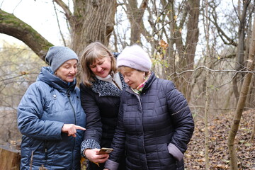three adult retired women elderly women enjoying a peaceful moment by the lake, embracing each other and sharing a heartwarming connection at sunset. High quality photo