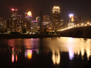 Obraz premium Vibrant Minneapolis Skyline at Night with Colorful River Reflections