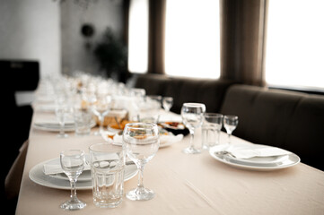 Elegant dining setup, Refined banquet scene preparation, Sophisticated feast arrangement with lighting, Chic wedding table set with exquisite glassware and ambiance