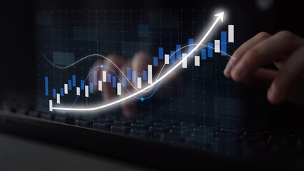A close-up view of hands on a keyboard with a digital financial chart showing upward trends. This image symbolizes growth and analysis in modern financial markets. Copula